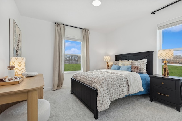 bedroom with baseboards and light carpet