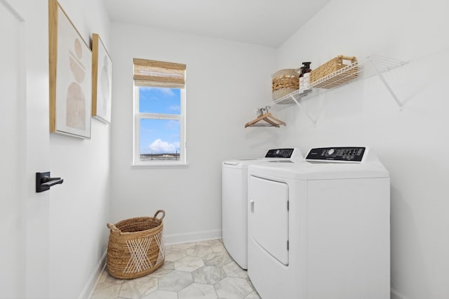 clothes washing area with laundry area, baseboards, and independent washer and dryer