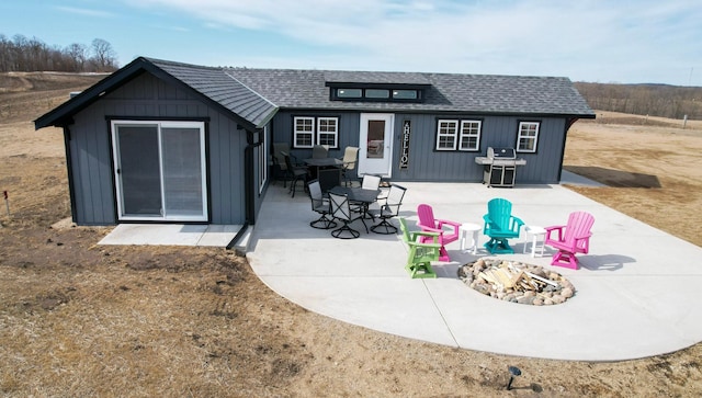 rear view of house with a patio and a shingled roof