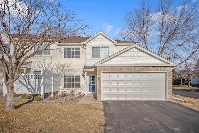 view of front of home with aphalt driveway, an attached garage, and a shingled roof