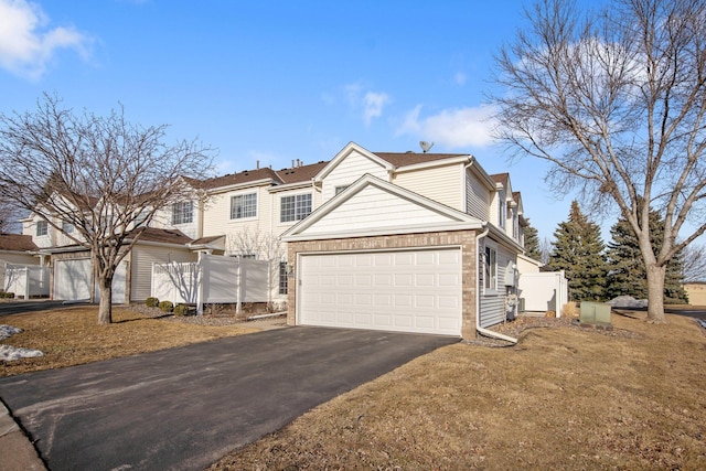 view of front of home with a garage, driveway, and fence