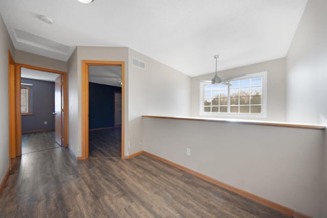 spare room with visible vents, baseboards, and dark wood-style flooring