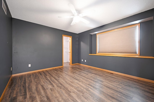 unfurnished room with visible vents, ceiling fan, baseboards, and wood finished floors