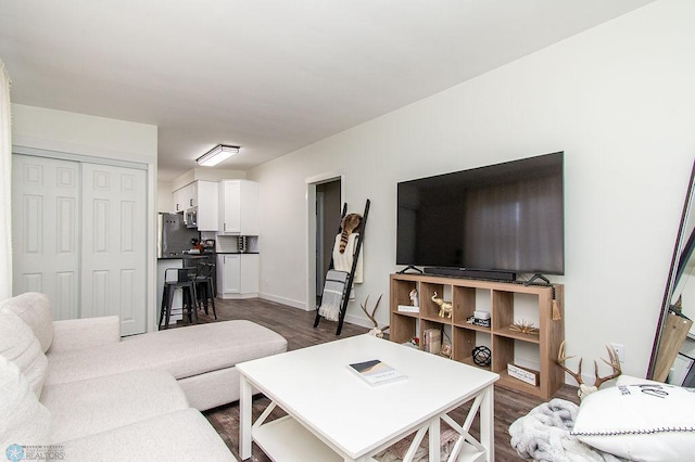 living room featuring dark wood-type flooring and baseboards