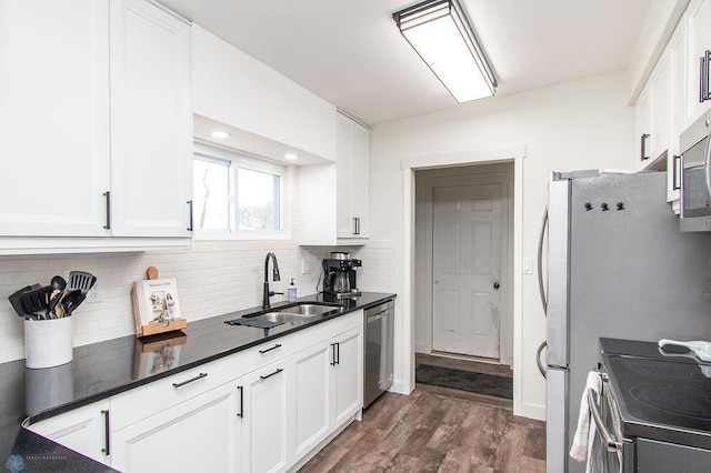 kitchen with decorative backsplash, white cabinetry, stainless steel appliances, and a sink