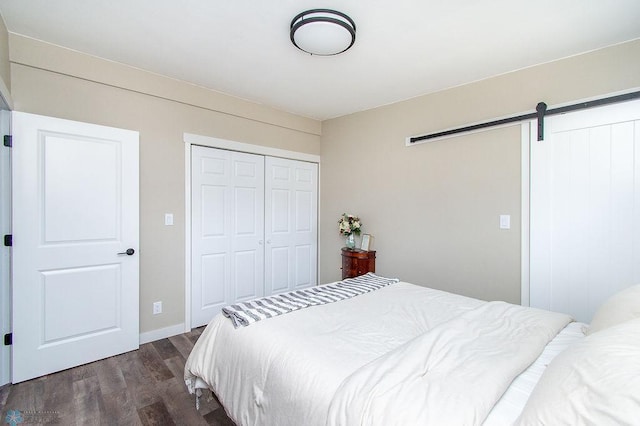 bedroom with dark wood-style floors, a closet, and a barn door