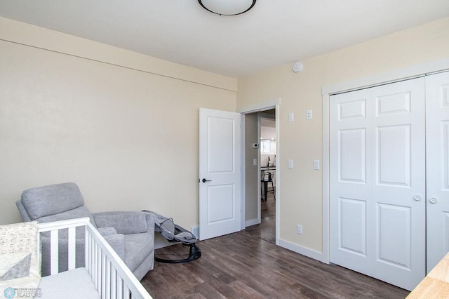 bedroom featuring a closet, baseboards, and dark wood-style floors