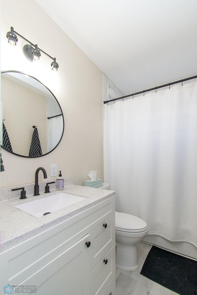 full bath with vanity, a shower with shower curtain, and toilet