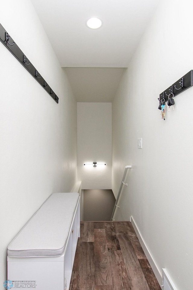 stairway with visible vents, baseboards, and wood finished floors