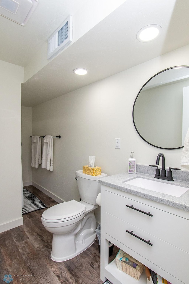 bathroom featuring visible vents, toilet, recessed lighting, wood finished floors, and vanity