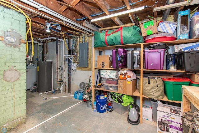 unfinished basement featuring electric panel and gas water heater