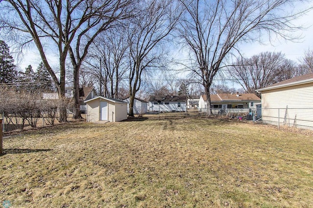 view of yard featuring a storage unit, a fenced backyard, and an outdoor structure