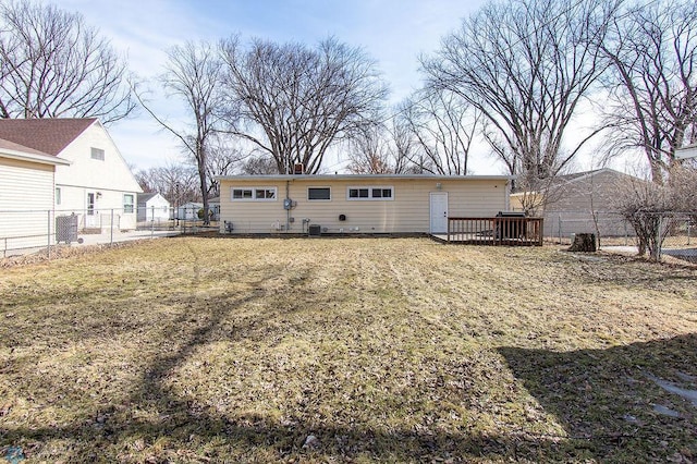 rear view of house with central air condition unit, a lawn, a wooden deck, and fence