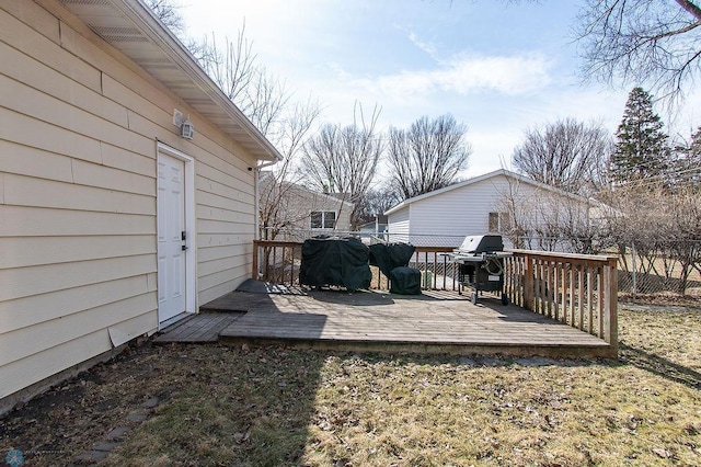 wooden terrace with a grill and fence