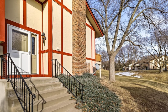 view of exterior entry featuring brick siding and stucco siding