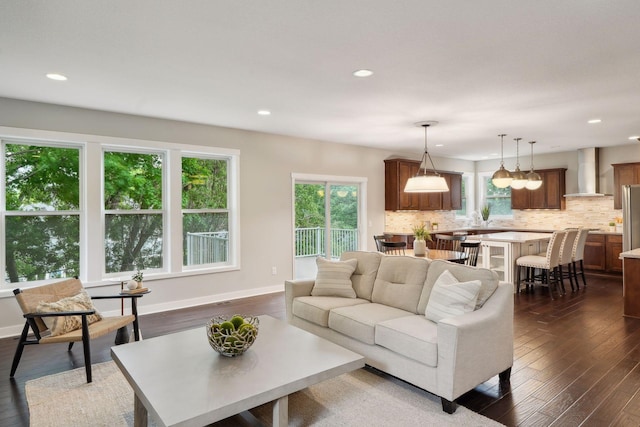 living room featuring a wealth of natural light, baseboards, and dark wood-type flooring