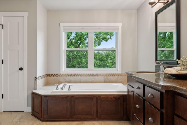 bathroom with plenty of natural light, a bath, and vanity