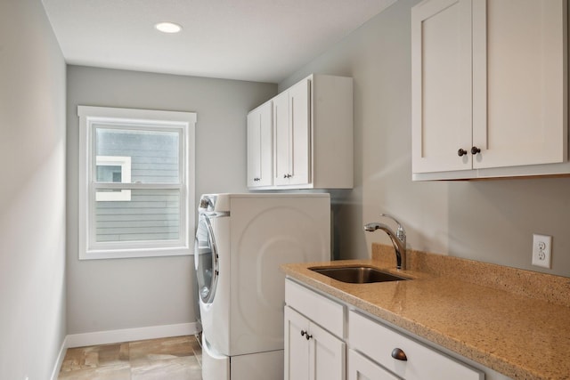 washroom with washer / clothes dryer, cabinet space, baseboards, and a sink