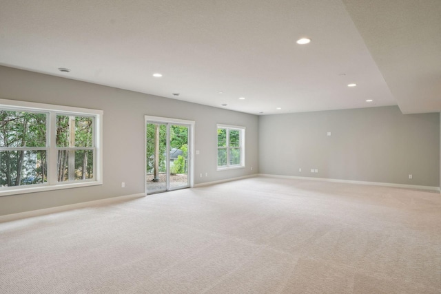 spare room with recessed lighting, baseboards, and light carpet