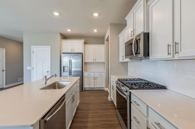 kitchen featuring dark wood-type flooring, a sink, white cabinetry, stainless steel appliances, and light countertops