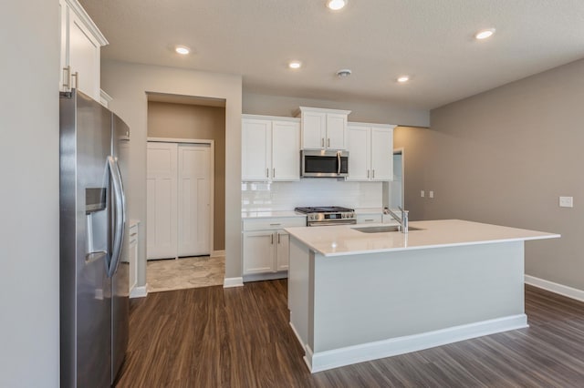 kitchen with a sink, tasteful backsplash, white cabinetry, and stainless steel appliances