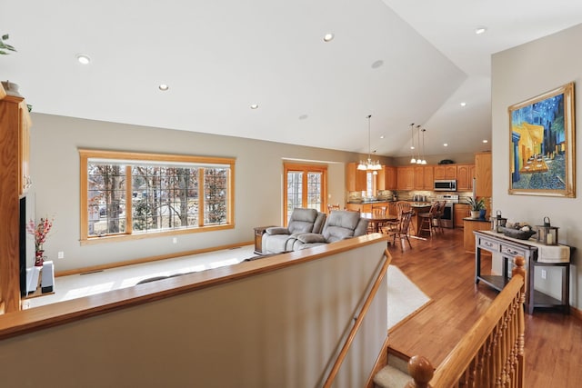 living area with recessed lighting, baseboards, lofted ceiling, and wood finished floors