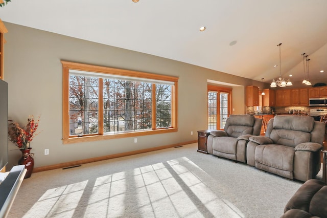 living area with lofted ceiling, baseboards, and light carpet