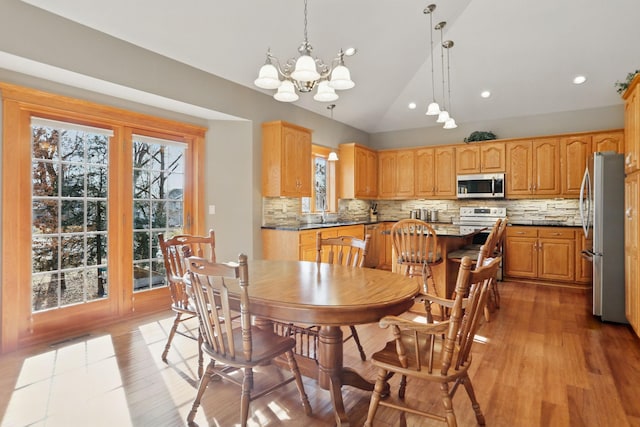 dining area featuring recessed lighting, light wood-style flooring, an inviting chandelier, and lofted ceiling