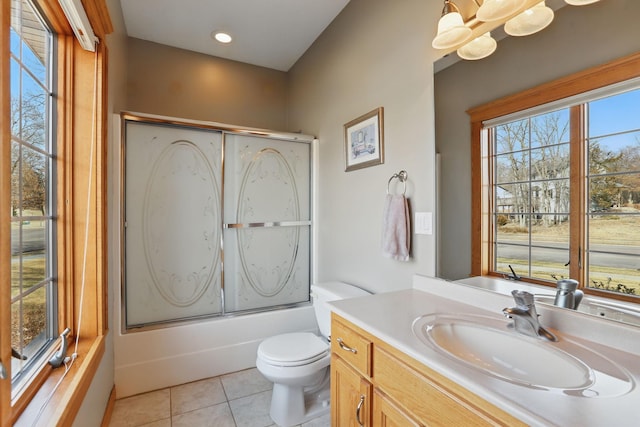 bathroom with vanity, tile patterned floors, toilet, and bath / shower combo with glass door