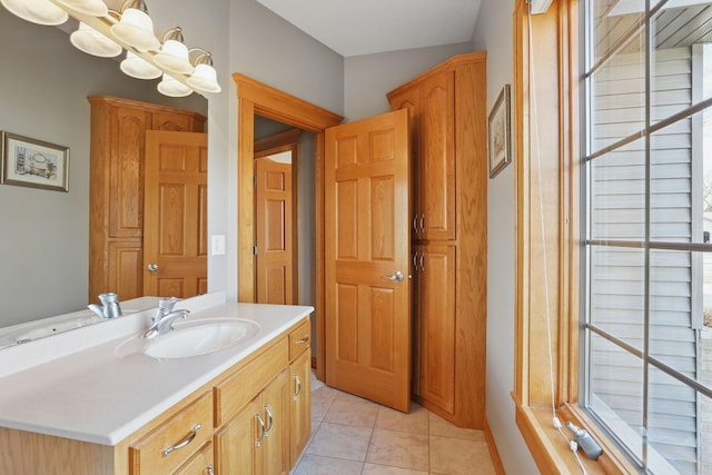 bathroom with tile patterned floors, plenty of natural light, vanity, and an inviting chandelier