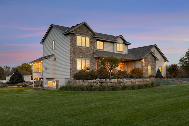 exterior space with a yard, stone siding, and roof with shingles