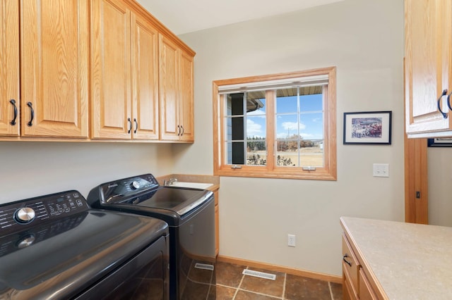 laundry room with baseboards, visible vents, washing machine and clothes dryer, cabinet space, and a sink