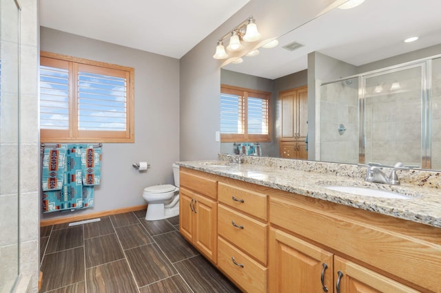 full bath featuring a shower stall, toilet, baseboards, and a sink