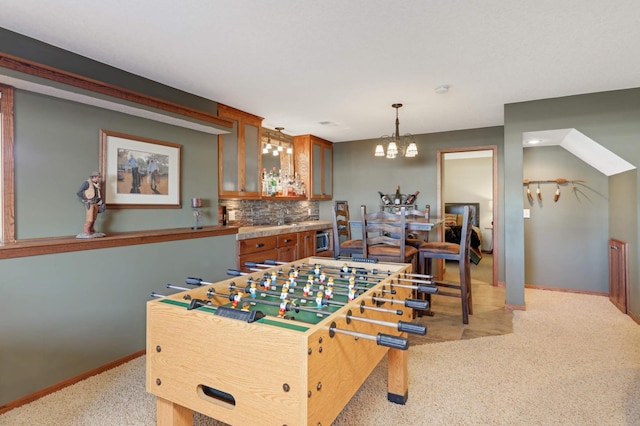 rec room with baseboards, an inviting chandelier, and light carpet