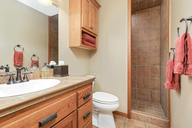 bathroom featuring vanity, a shower stall, toilet, and tile patterned flooring