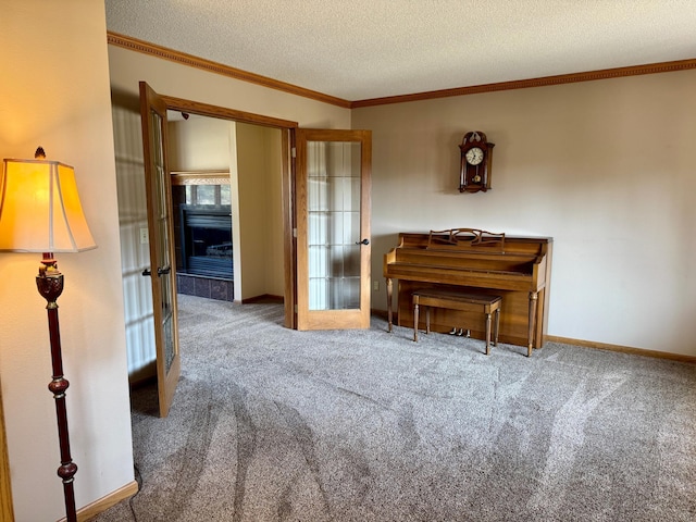 unfurnished room featuring a textured ceiling, french doors, carpet flooring, crown molding, and baseboards