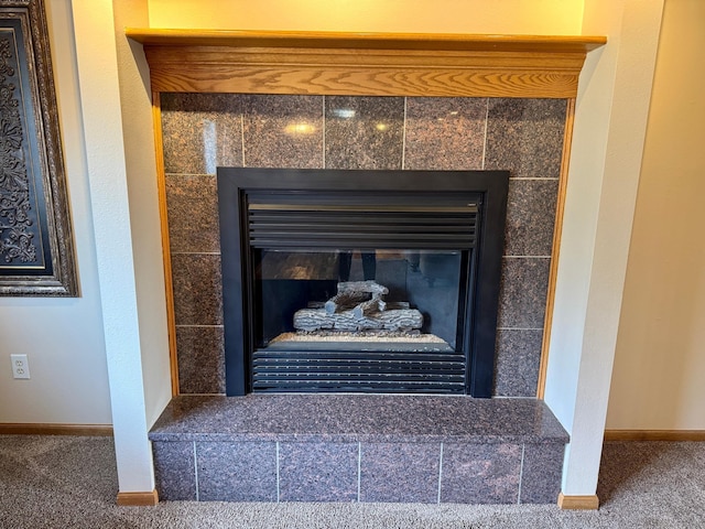 interior details featuring baseboards, carpet, and a fireplace