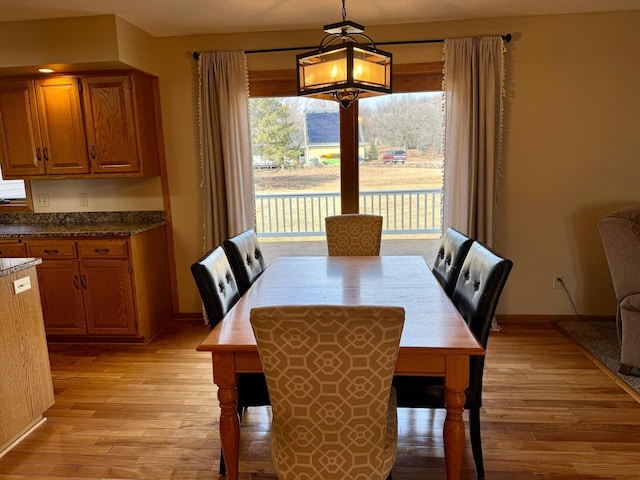 dining area with light wood-style floors and baseboards