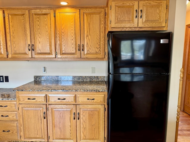 kitchen with brown cabinets and freestanding refrigerator