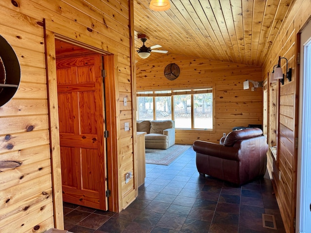 living room featuring visible vents, wooden walls, lofted ceiling, wood ceiling, and ceiling fan