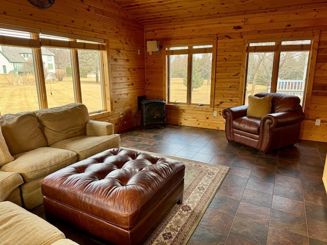 living area with wood walls, a wood stove, and lofted ceiling