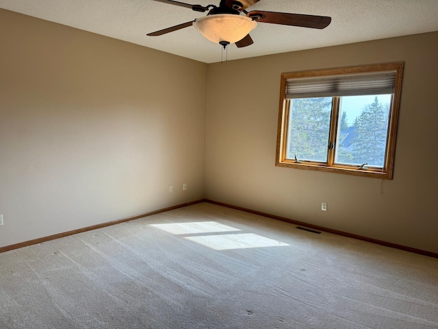 empty room featuring visible vents, a textured ceiling, baseboards, and carpet