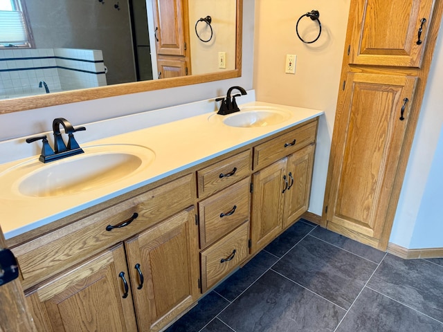 bathroom featuring a sink, baseboards, double vanity, and tile patterned floors