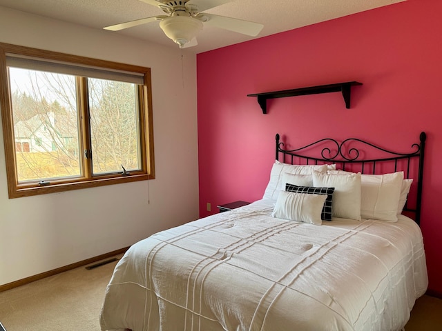 carpeted bedroom featuring visible vents, baseboards, and ceiling fan