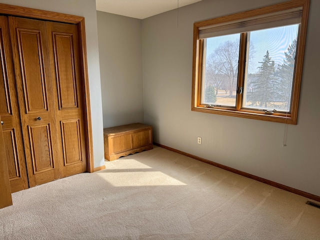 unfurnished bedroom featuring multiple windows, baseboards, and carpet