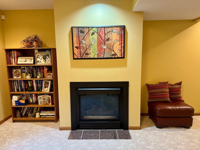 interior details featuring baseboards, a fireplace with flush hearth, and carpet