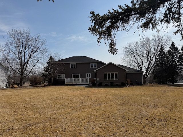 back of property with a lawn and a deck