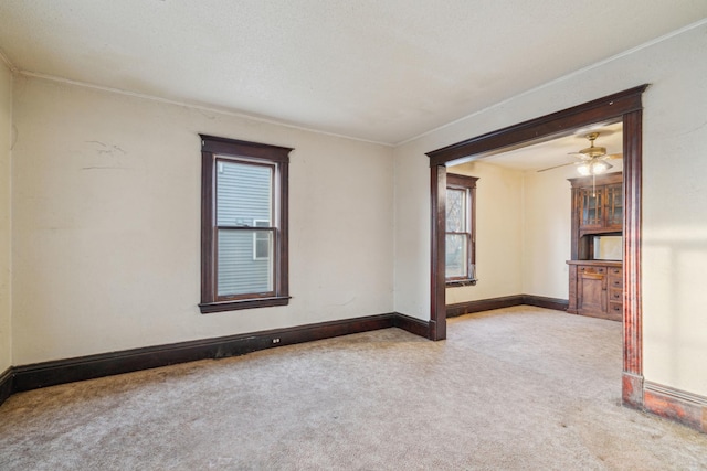 spare room featuring carpet flooring, a ceiling fan, and baseboards