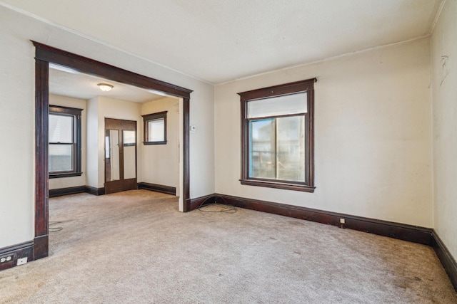 carpeted empty room featuring baseboards