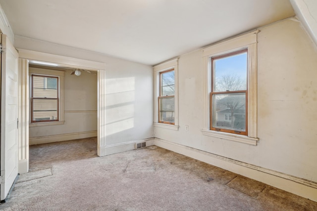 carpeted spare room featuring visible vents and vaulted ceiling